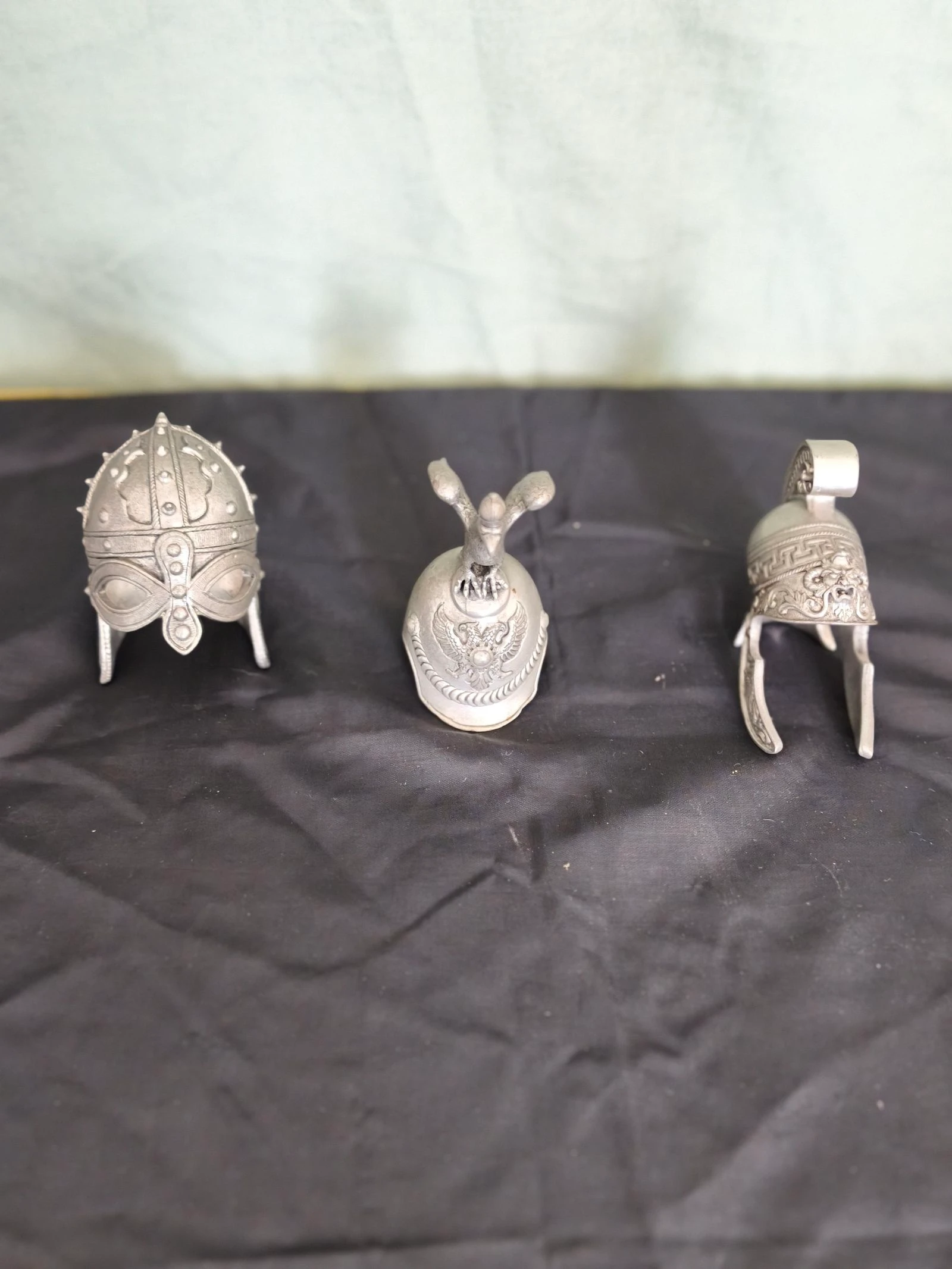 Conjunto de três capacetes históricos miniaturas decorativos em metal.